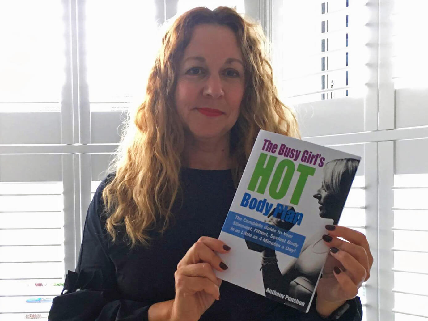 Jo holding The Busy Girl’s HOT Body Plan book