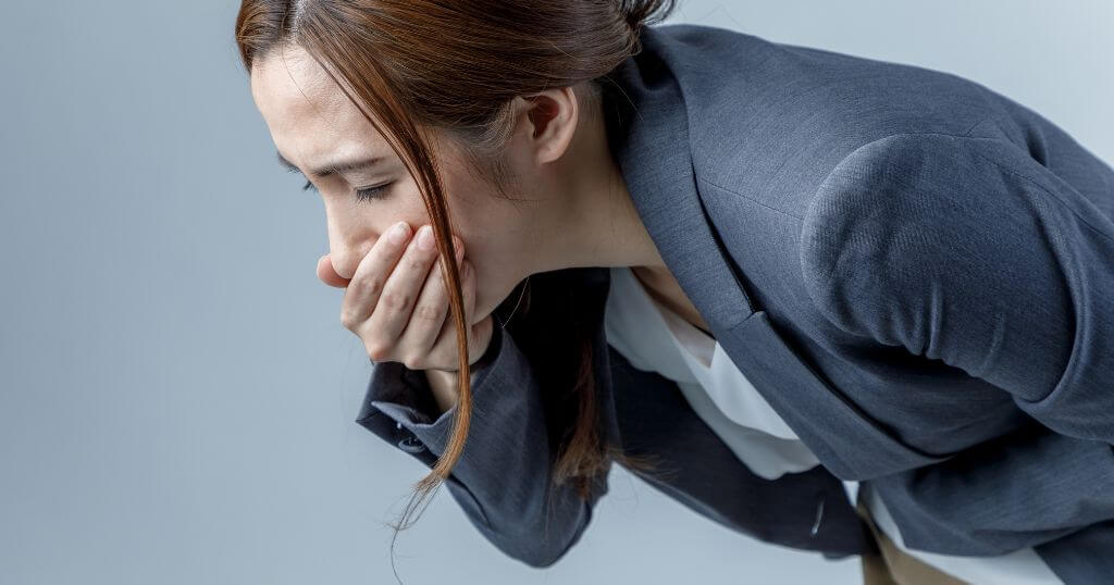 Woman experiencing nausea, illustrating a common side effect associated with GLP-1 weight loss injections.